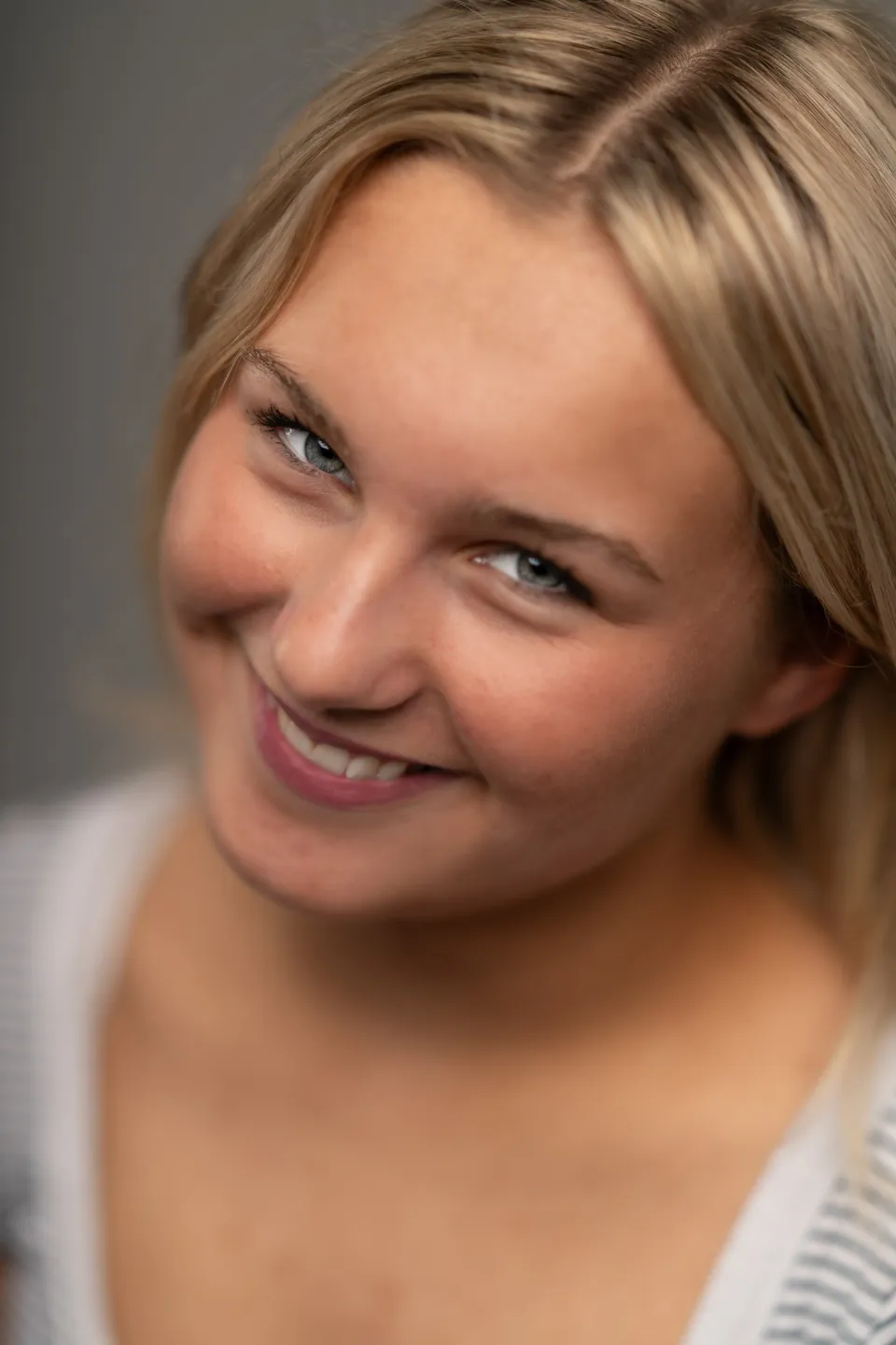Ung kvinde smiler i studieportræt