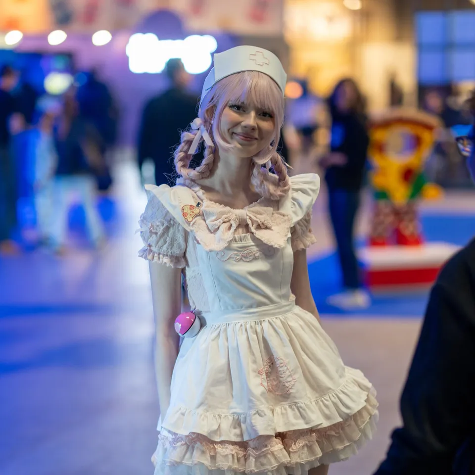 Cosplayer i hvid kjole på messegulvet