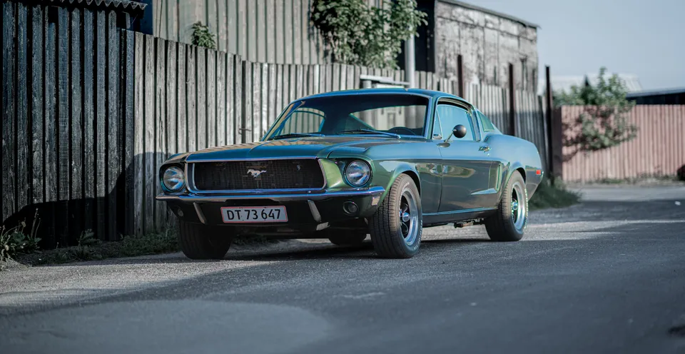 Grøn Ford Mustang ved et hus
