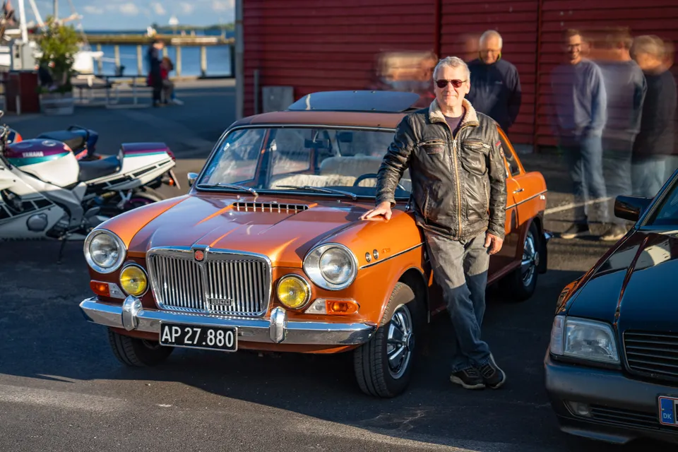 Orange klassisk bil med ejer